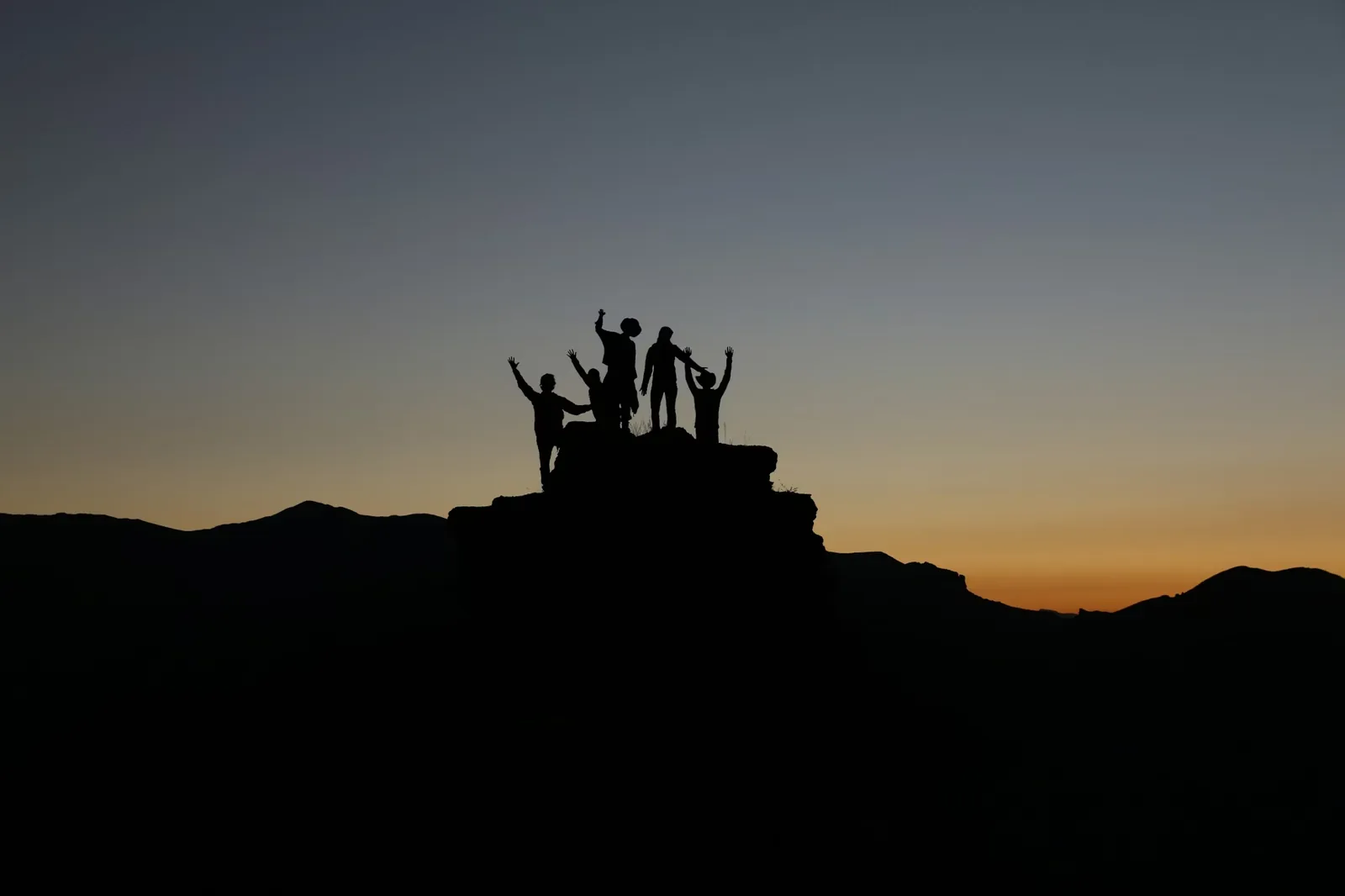 Person holding child's hand walking in village setting