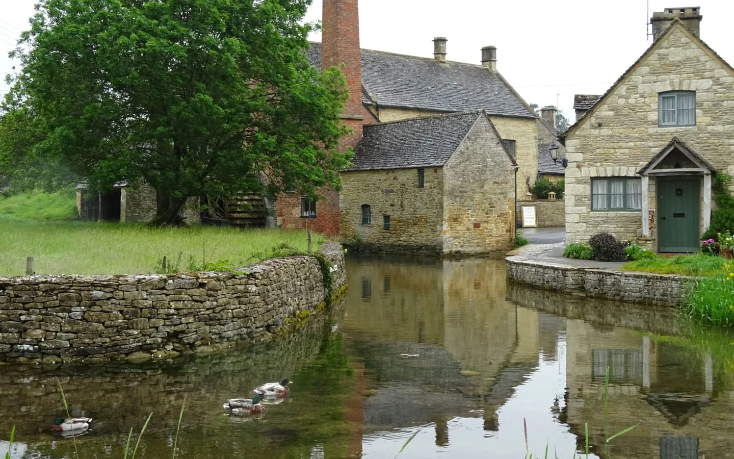 Stone cottages beside a mill pond in an English village